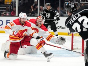 Los Angeles Kings forward Kevin Fiala shoots the puck as Calgary Flames defenceman MacKenzie Weegar, left, and goaltender Jacob Markstrom defend at Crypto.com Arena in Los Angeles on Thursday, April 11, 2024. Markstrom stopped the shot on the play.