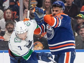 Vancouver Canucks' Carson Soucy (7) and Edmonton Oilers' Evander Kane (91) rough it up during second period NHL action in Edmonton on Saturday, April 13, 2024.