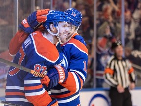 Edmonton Oilers captain Connor McDavid (97) celebrates his 100th assist of the season with Zach Hyman (18) against the San Jose Sharks in Edmonton on Monday, April 15, 2024.