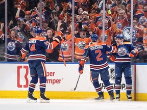 Edmonton Oilers' Mattias Ekholm (14), Evan Bouchard (2) and Zach Hyman (18) celebrate a goal against the Los Angeles Kings during first period of Game 1 first round NHL Stanley Cup playoff hockey action in Edmonton, Monday, April 22, 2024.