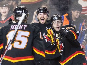 Calgary Flames forward Matt Coronato, right, celebrates a goal against the Vegas Golden Knights with MacKenzie Weegar, centre, and Dryden Hunt at the Scotiabank Saddledome in Calgary on Thursday, March 14, 2024.