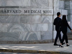 Pedestrians walk towards the Harvard Medical School, Thursday, Aug. 18, 2022, in Boston.