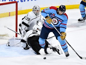 Los Angeles Kings' Matt Roy (3) gets tangled up with Winnipeg Jets' Nino Niederreiter (62) in front of Kings goaltender Cam Talbot (39) during the third period of NHL action in Winnipeg on Monday April 1, 2024.