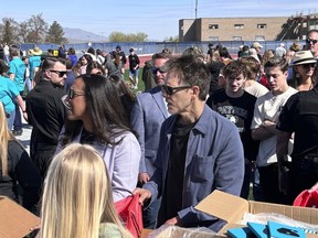 In this photo provided by Jesse Sorenson, actor Kevin Bacon, center, helps fill care packages for his charity, Saturday, April 20, 2024, in Payson, Utah, while visiting the Utah high school where cult classic "Footloose," was filmed.