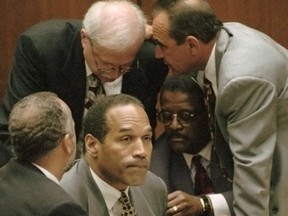 O.J. Simpson is surrounded by his defenseattorneys, clockwise from left, Ken Spaulding, back towards camera, Gerald Uelmen, Robert Shapiro and Johnnie Cochran Jr., as they discuss their plans for arguing the admissibility of the tapes of retired Los Angeles police detective Mark Fuhrman during his trial, Tuesday, Aug. 29, 1995 in Los Angeles.