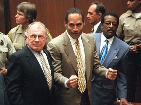 Murder defendant O.J. Simpson (centre) listens to the not guilty verdict with his attorneys F. Lee Bailey (left) and Johnnie Cochran Jr. (right) in Los Angeles on Oct. 3, 1995.