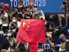 A Chinese flag is unfurled on the podium of a swimming event final at the 2020 Summer Olympics, on July 29, 2021, in Tokyo, Japan.