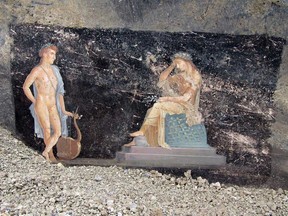 This handout picture released by the archaelogical park of Pompeii on April 11, 2024 shows frescoes depicting mythological characters Appolo and Cassandra, the daughter of Priam, in a banqueting room with black walls part of the ongoing excavations in the block 10 of Regio IX, in Pompeii, near Naples.