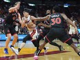 Miami Heat guard Tyler Herro drives through the defence of Toronto Raptors forward Kelly Olynyk (41), guard Javon Freeman-Liberty (0), and guard Ochai Agbaji (30) during the first half of an NBA basketball game, Sunday, April 14, 2024, in Miami.