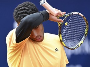 Canada's Felix Auger Aliassime wipes his face during the men's singles quarterfinal match against Germany's Jan-Lennard Struff at the ATP Tour in Munich, Germany, Saturday April 20, 2024.