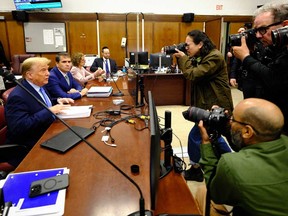 Photojournalists take pictures as former U.S. president Donald Trump attends his trial for allegedly covering up hush money payments linked to extramarital affairs, at Manhattan Criminal Court in New York City on April 26, 2024.
