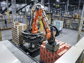 A robot unloads a pallet of cat food at a Walmart distribution centre in Calgary, Thursday, March 28, 2024.