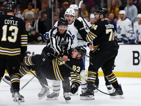 Linesman Andrew Smith knocks Brad Marchand of the Boston Bruins to the ground to separate him from a fight with Pontus Holmberg of the Toronto Maple Leafs in Game 5.