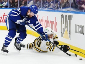 Toronto Maple Leafs' Morgan Rielly (44) battles for the puck with Boston Bruins' David Pastrnak (88).