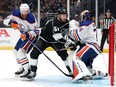 Mattias Ekholm (14) and Stuart Skinner (74) of the Edmonton Oilers push Trevor Lewis (61) of the Los Angeles Kings in the crease during Game 3 of their 2024 Stanley Cup -playoff series at Crypto.com Arena on April 26, 2024, in Los Angeles, Calif.