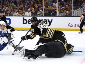 Tyler Bertuzzi #59 of the Toronto Maple Leafs falls as he takes a shot defended by Matt Grzelcyk #48 of the Boston Bruins during the second period of Game Five of the First Round of the 2024 Stanley Cup Playoffs at TD Garden on April 30, 2024 in Boston, Massachusetts.