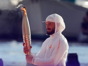French rapper Julien Mari, a.k.a. Jul, holds the Olympic Torch during the Olympic Flame arrival ceremony at the Vieux-Port ahead of the Paris 2024 Olympic and Paralympic Games, in Marseille, France, on Wednesday, May 8, 2024.