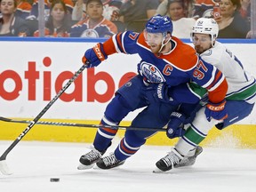 Connor McDavid (97) of the Edmonton Oilers skates against Teddy Blueger (53) of the Vancouver Canucks in Game 4 of their Western Conference second-round playoff series at Rogers Place on May 14, 2024, in Edmonton.