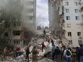 Firefighters and volunteers operate to secure the area on the site of a partially collapsed apartment building which was damaged by a Ukrainian strike in Belgorod on May 12, 2024.