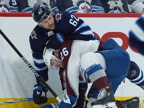 Sean Walker of the Colorado Avalanche is tied up by Nino Niederreiter of the Winnipeg Jets in Game 5 on Tuesday.
