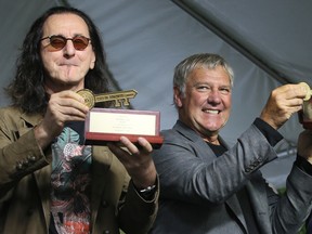 Rush bassist and vocalist Geddy Lee and guitarist Alex Lifeson receive the keys to the city from former Toronto mayor John Tory at the opening of the Lee Lifeson Art Park in Willowdale on Sept. 17, 2016.