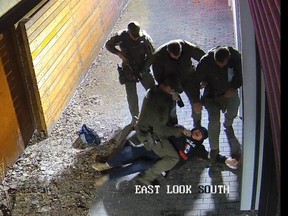 Surveillance camera still showing the March 23, 2021, arrest of Lee Van Beaver near Ritchie Market in Edmonton. Beaver surrendered to police but suffered what a judge called "assaultive" arrest. Two officers — Oli Olason and Dustin Adsett — were charged with assaulting Beaver. Adsett was acquitted, while Olason goes to trial next spring.