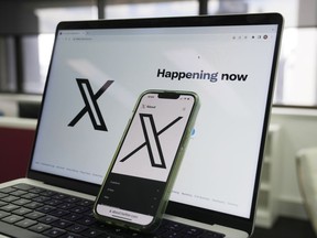 The opening page of X is displayed on a computer and phone in Sydney on Oct. 16, 2023.