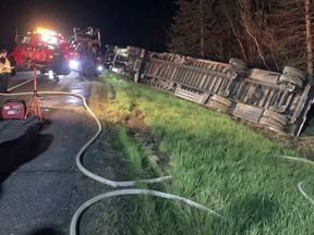 In this image provided by Maine State Police, emergency crews work to remove a tractor-trailer hauling 15 million bees after it overturned on Interstate-95, May 10, 2024, in Clinton, Maine.