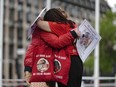 Infected blood campaigners hug during a gathering at Parliament Square, ahead of the publication of the final report into the scandal, in London, Sunday, May 19, 2024.