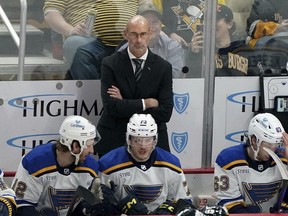 FILE - St. Louis Blues interim head coach Drew Bannister stands behind the bench during the first period of an NHL hockey game against the Pittsburgh Penguins, Saturday, Dec. 30, 2023, in Pittsburgh. The St. Louis Blues have removed the interim tag from Drew Bannister's title and named him their full-time coach. President of hockey operations and general manager Doug Armstrong announced the move Tuesday, May 7, 2024.