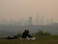 Smoke from wildfires blankets the city as a couple has a picnic in Edmonton, Saturday, May 11, 2024.