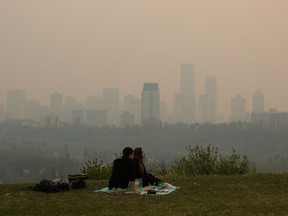 Smoke from wildfires blankets the city as a couple has a picnic in Edmonton, Saturday, May 11, 2024.