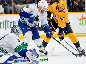 Vancouver Canucks defenceman Ian Cole passes the puck away from Nashville Predators centre Ryan O'Reilly during the Stanley Cup first-round playoff series Friday, May 3 in Nashville.