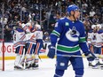 Edmonton Oilers goalie Stuart Skinner, back left, and his teammates celebrate as Vancouver Canucks' Dakota Joshua, front, looks on after Edmonton defeated Vancouver 3-2 in Game 7 on Monday night at Rogers Arena