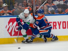 Dylan Holloway (55) of the Edmonton Oilers, checks Quinn Hughes (43) of the Vancouver Canucks at Rogers Place in Edmonton on May 12, 2024. Photos by Shaughn Butts-Postmedia