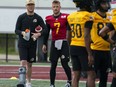 Hamilton Tiger-Cats quarterback Bo Levi Mitchell (left) speaks with quarterback Taylor Powell (7) during the first day of training camp at Ron Joyce Stadium at McMaster University in Hamilton on Sunday, May 12, 2024.