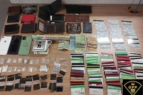 Some of the credit cards, identity documents and drugs seized during a May 29 routine traffic stop in Brampton which led to three people being charged with 292 offences.