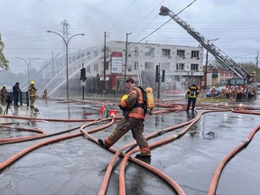 Firefighters at the scene of a five-alarm-fire at the corner of Côte-St-Luc Rd. and Robert-Burns St. in Montreal on Sunday, May 5, 2024.
