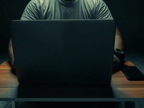 A man works on a laptop computer.