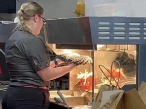 Screenshot of McDonald's worker holding dirty mop head under fries heat lamp.