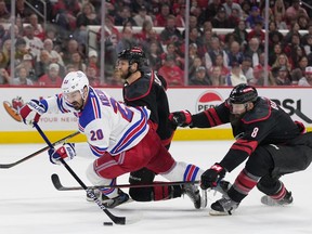 Chris Kreider of the New York Rangers shoots the puck as Jaccob Slavin and Brent Burns of the Carolina Hurricanes defend during Game 6 at PNC Arena on May 16, 2024 in Raleigh, North Carolina.