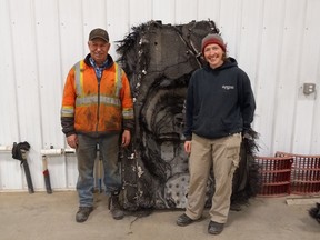 Barry Sawchuk (left) and Samantha Lawler, an associate professor of astronomy at the University of Regina, pose near a piece of space debris found on his farm in February.