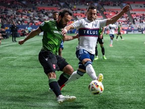 Cavalry FC's Sergio Camargo, left, and Vancouver Whitecaps' Luís Martins, right, compete for ball possession during the first half of a Canadian Championship quarterfinal soccer match, in Vancouver, on Tuesday, May 21, 2024.