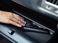 A man taking a handgun from the glovebox compartment inside a car.