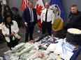Justice Minister Matt Wiebe (centre left) and Insp. Elton Hall from the Winnipeg Police Service organized crime unit look at the haul from an interprovincial drug network bust at headquarters in Winnipeg on Wed., May 1, 2024. KEVIN KING/Winnipeg Sun