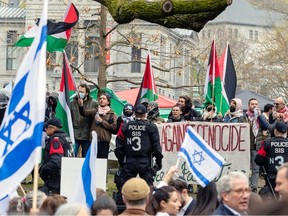 Montreal police stand between pro-Israeli counter-protesters and the pro-Palestinian encampment on the campus of McGill University in Montreal on Thursday, May 2, 2024.
