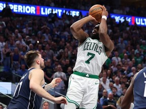 Jaylen Brown of the Boston Celtics attempts a shot while being guarded by Luka Doncic of the Dallas Mavericks in the fourth quarter in Game Three of the 2024 NBA Finals at American Airlines Center on June 12, 2024 in Dallas.