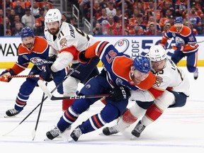 Anton Lundell #15 of the Florida Panthers slows down Connor McDavid #97 of the Edmonton Oilers during Game Four of the 2024 Stanley Cup Final at Rogers Place. (Photo by /