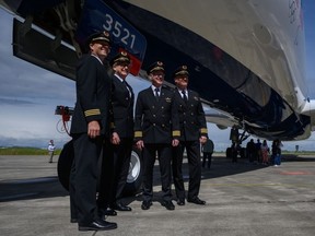 Pilots pose for a photo next to a Delta Air Lines' Airbus A350-900 aircraft during an unveiling event for Delta's team USA livery for the Paris 2024 Olympic Games, at the Airbus delivery centre in Toulouse, south-western France on May 2, 2024.