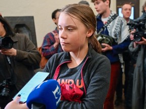 Swedish climate activist Greta Thunberg speaks with journalists as she arrives on May 8, 2024 at the Stockholm district court.